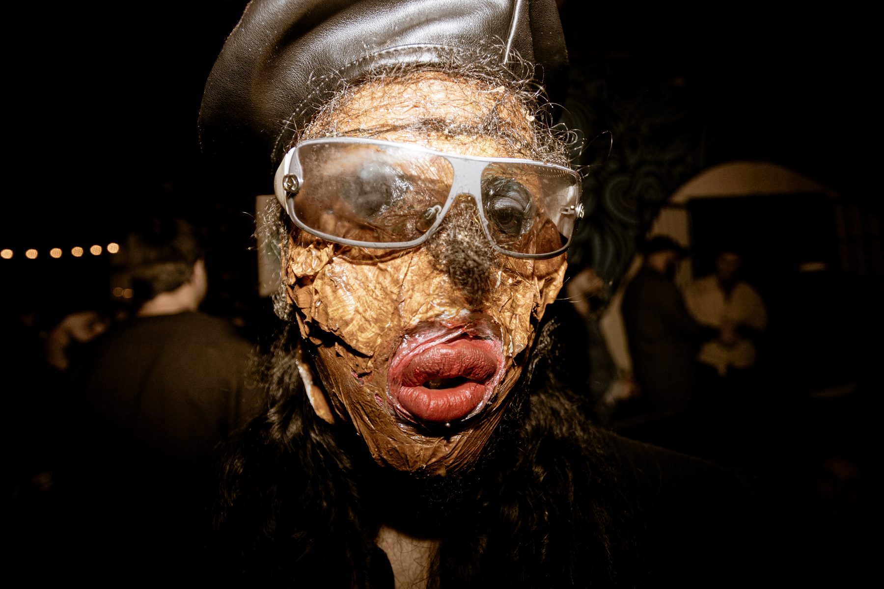 wiqi close-up in a textured latex mask and sunglasses at a live show